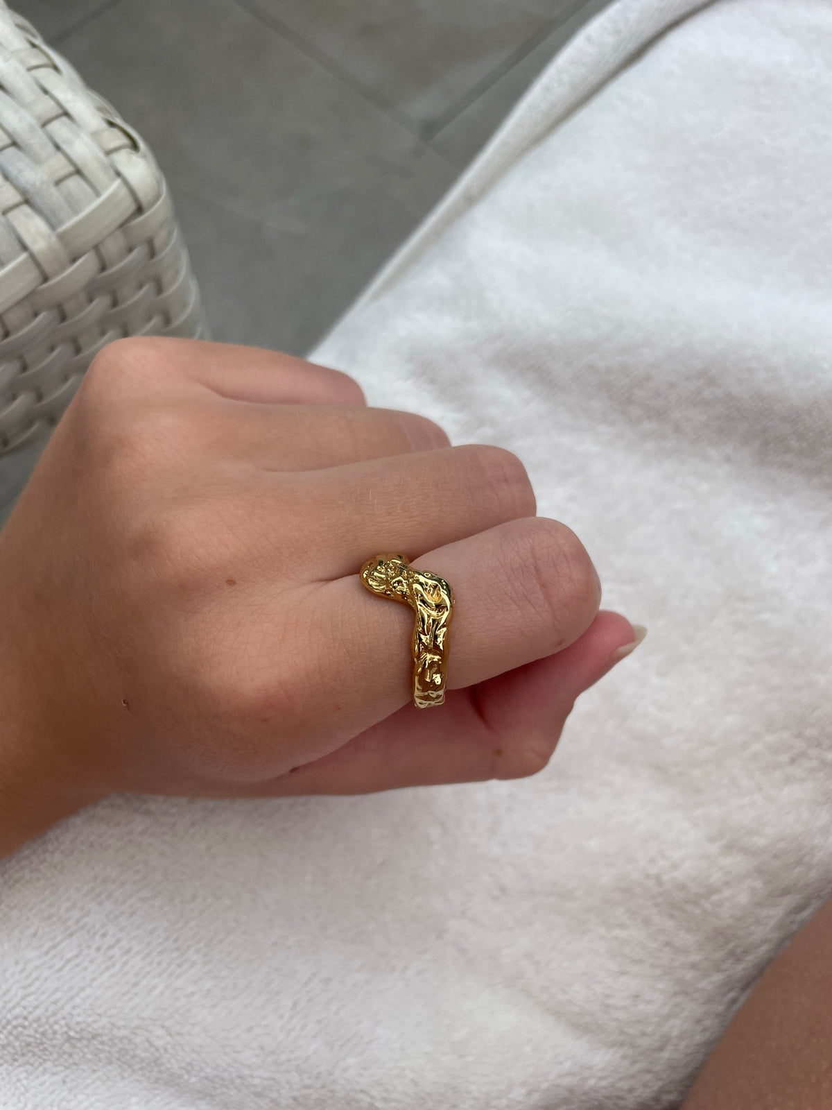 Woman wearing gold-plated hammered V-shape wave ring on hand